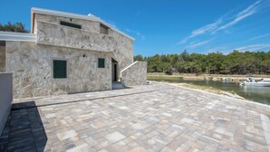 A stone building with a paved patio and a view of a river.