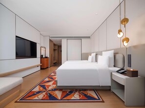 Een moderne hotelkamer met een groot bed, een televisie, een bureau en een badkamer.