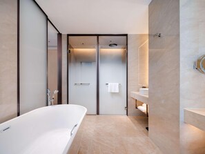 Een moderne badkamer met een vrijstaand bad, een douchecabine met glazen wanden en een wastafel met spiegel.