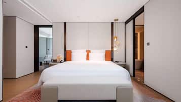 Quarto de hotel moderno com uma cama grande, uma escrivaninha e uma cadeira.