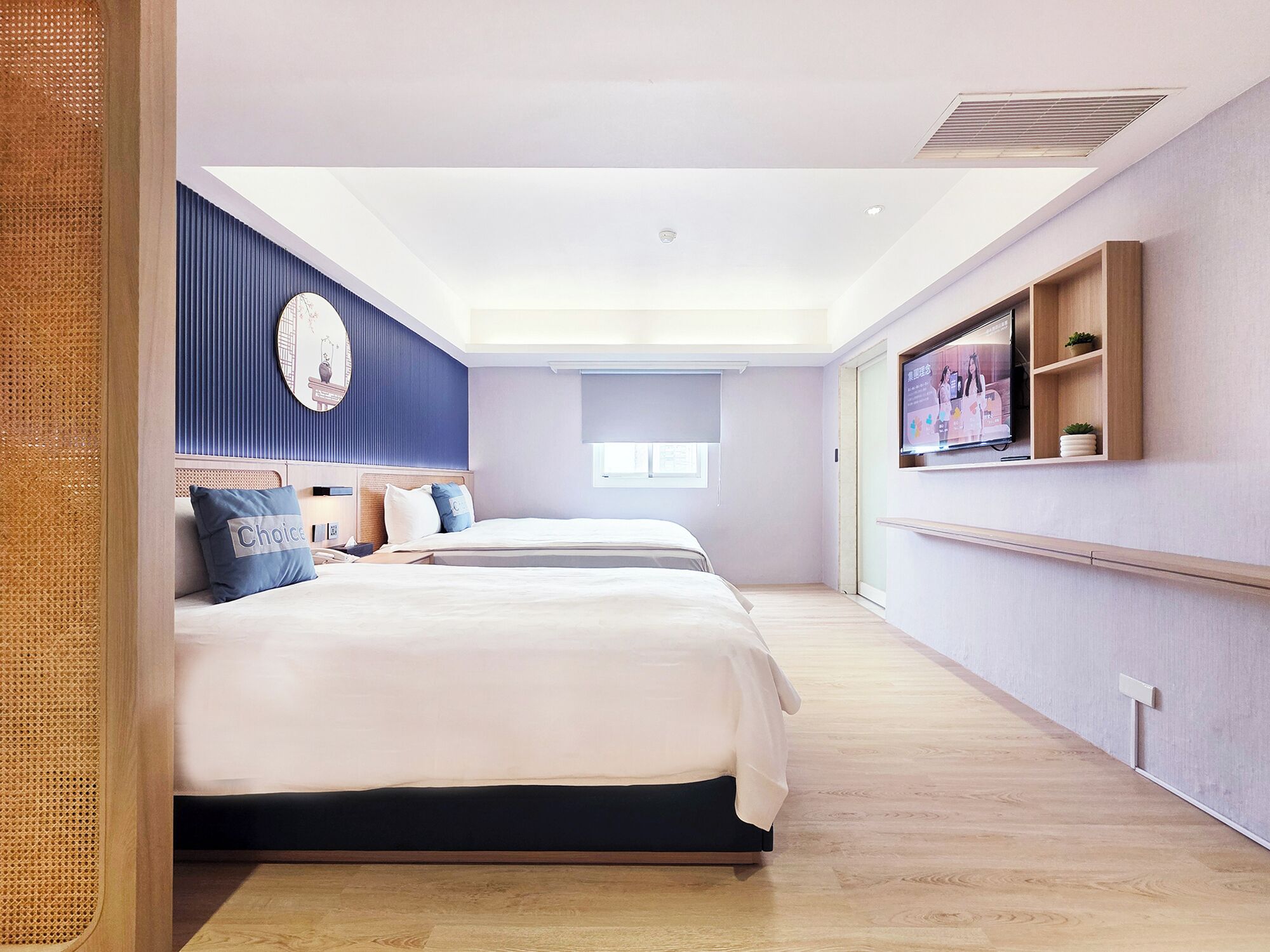 A modern hotel room with a large bed, a TV, and a window.