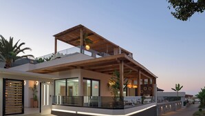 Een modern huis met twee verdiepingen, een balkon, grote ramen en een verzorgde entree.
