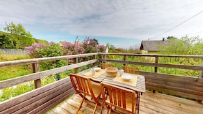 A wooden deck with a table and chairs, surrounded by a wooden railing. - Gite du Holzweg Les Cigognes Duplex (Mittelbergheim)