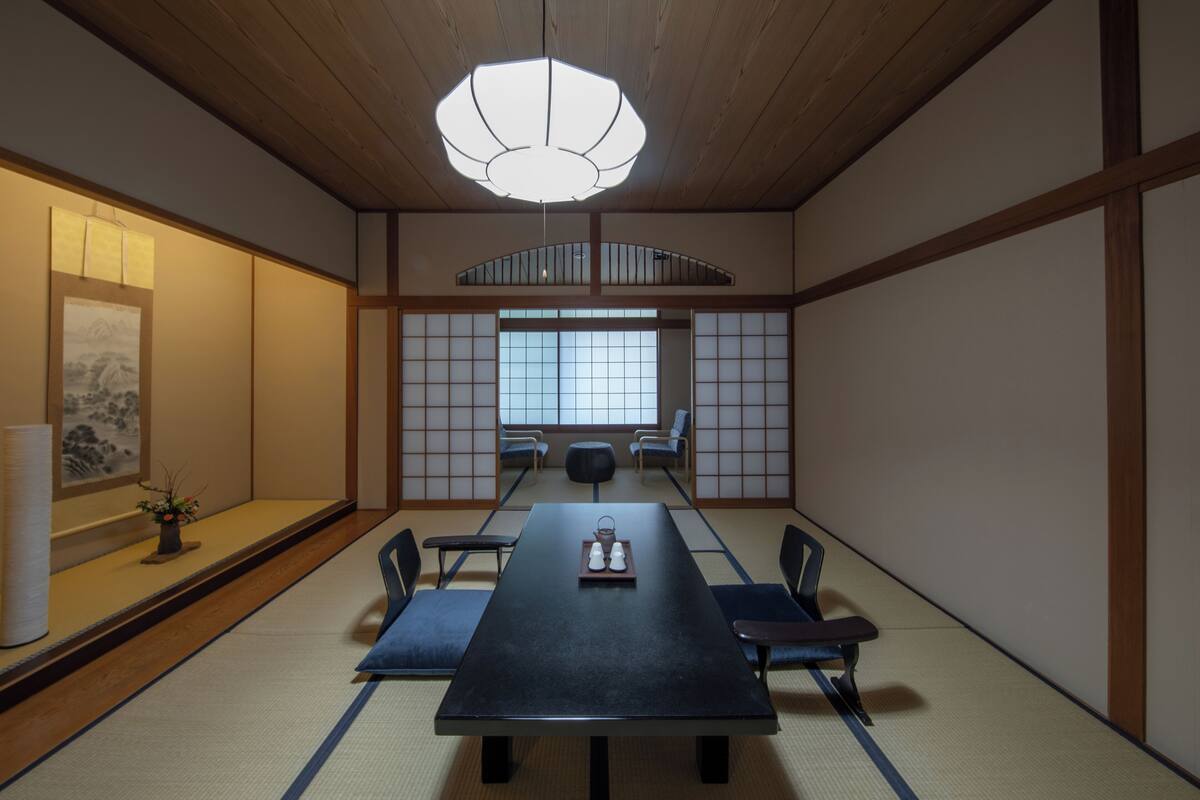 Ein traditioneller japanischer Raum mit Tatami-Boden, einem niedrigen Tisch und Shoji-Schirmen.