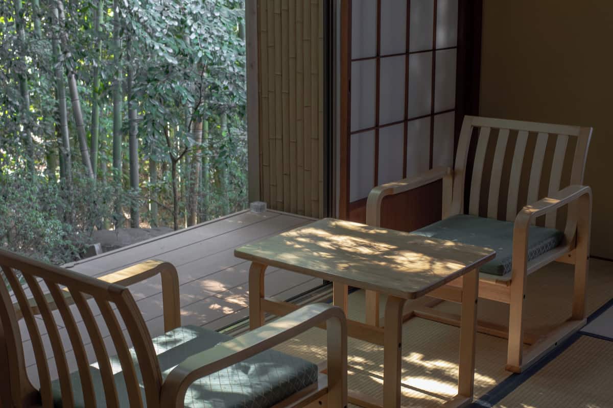 Ein traditioneller japanischer Raum mit Tatami-Boden, einem niedrigen Holztisch und zwei Tatami-Matten mit Kissen.