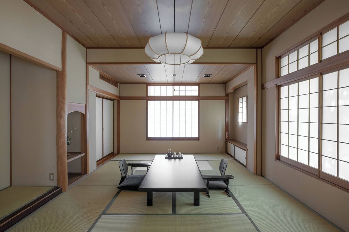 Ein traditioneller japanischer Raum mit Tatami-Böden, einem niedrigen Tisch und Schiebetüren.