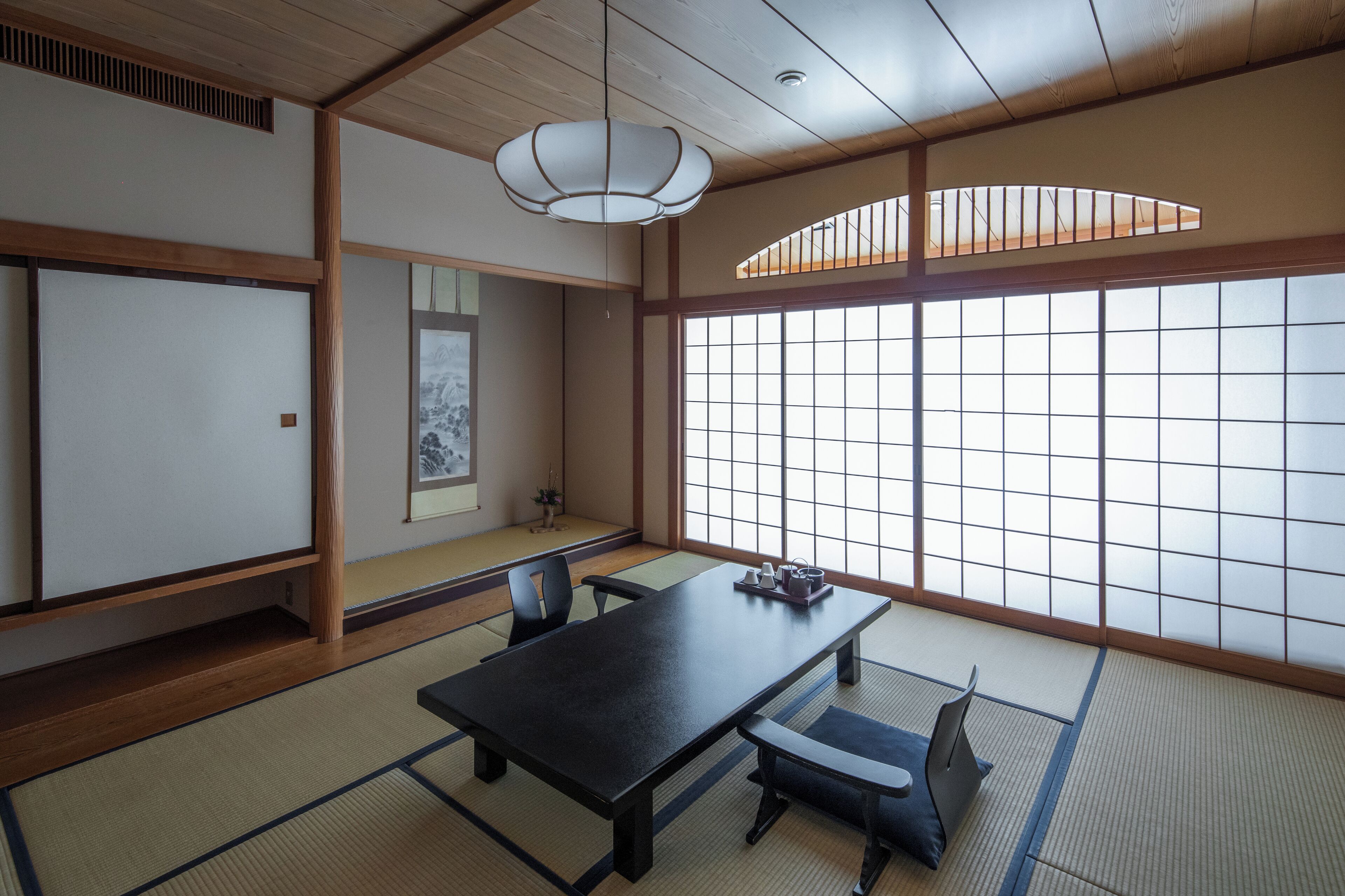 A traditional Japanese room with tatami flooring, a low table, and sliding doors.