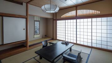 A traditional Japanese room with tatami flooring, a low table, and sliding doors.