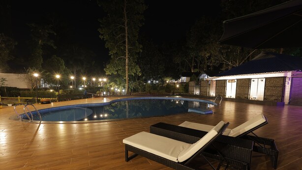 Une piscine avec des chaises longues et une terrasse en bois.