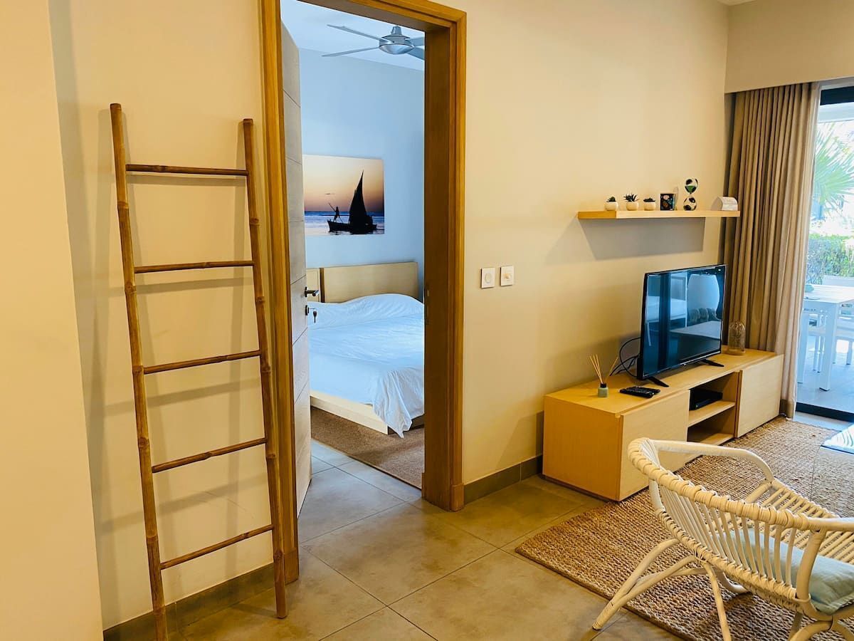 Une chambre d’hôtel avec un lit, une télévision, une petite table, une chaise, une échelle et une vue sur l’extérieur.