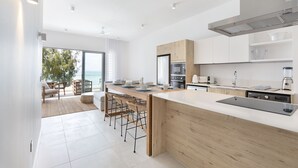 A modern kitchen with a large island, wooden cabinets, and a view to the outside. - Ocean Grand Gaube (Grand Gaube)