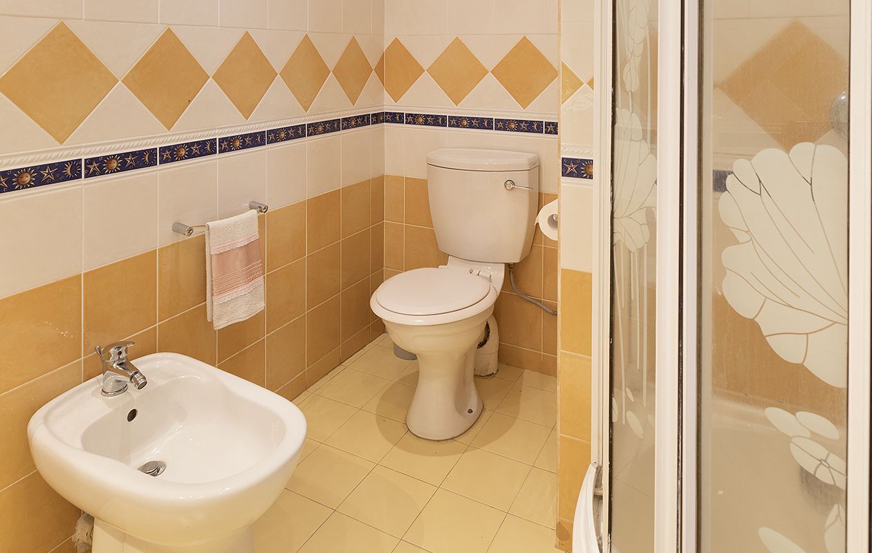 A bathroom with a toilet, bidet, and sink.
