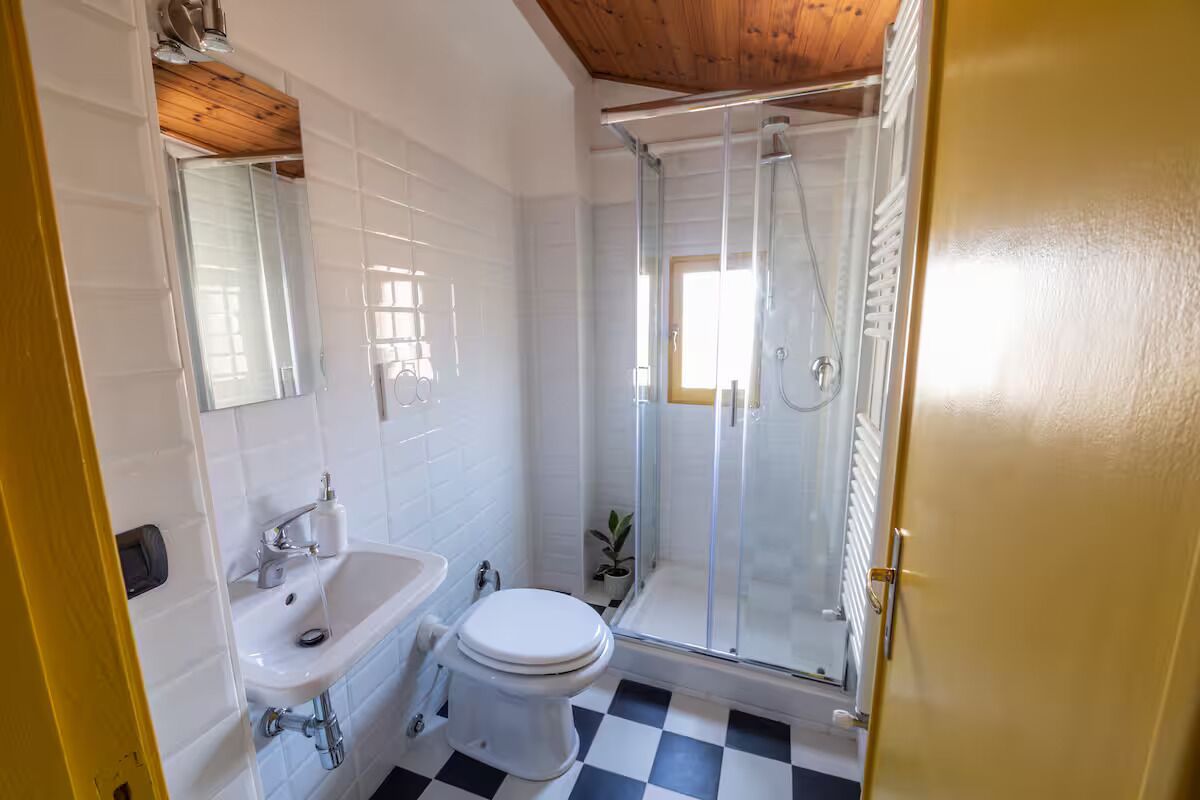 Ein Badezimmer mit Waschbecken, Toilette und Duschkabine aus Glas.