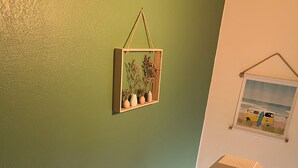 Una escalera con una pared verde y un cuadro con una camioneta y una tabla de surf.
