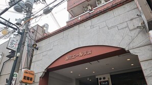 La entrada de un edificio con un letrero que dice "ルミエール天満" y otro que indica "大野ホテル五丁目".