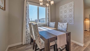 Un coin repas avec une table en bois, des chaises à motifs floraux et un lustre.