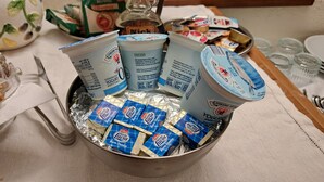 A bowl filled with various food items including packaged snacks and dairy products. - Il Flauto Magico (Belmonte Calabro)