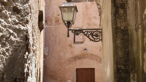 A narrow alleyway with a traditional street lamp and a wooden door at the end. - Il Flauto Magico (Belmonte Calabro)