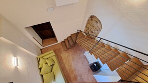 A staircase with a metal railing, a small alcove with a door, and a tiled floor. - Il Flauto Magico (Belmonte Calabro)