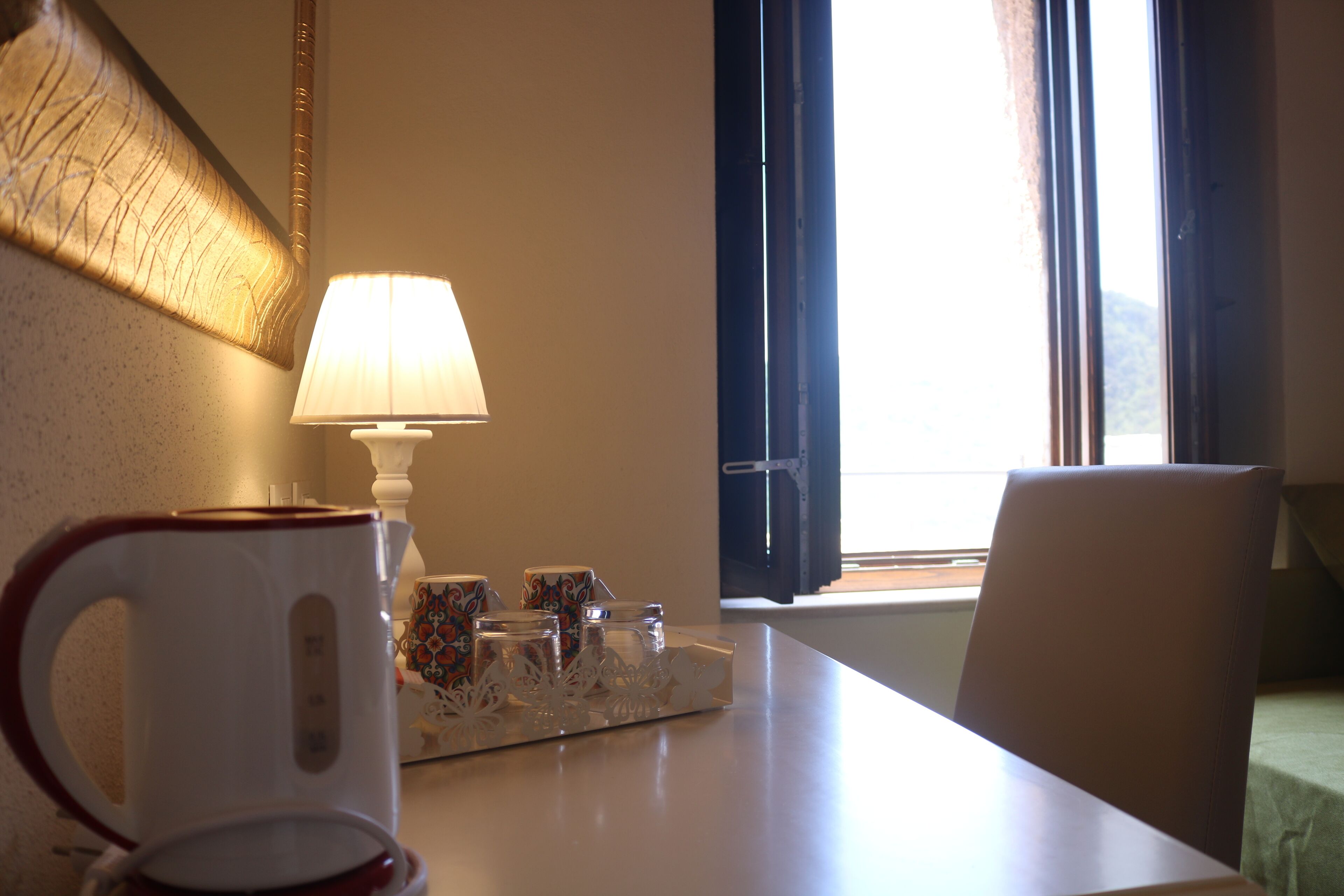 Une table avec une tasse blanche, une lampe et un plateau contenant de petits récipients.