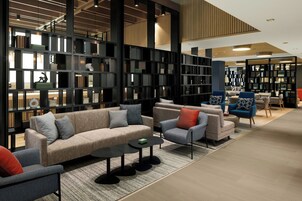 A modern library with sofas, armchairs, and a coffee table.