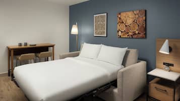 Un dormitorio moderno con cama, mesita de noche, lámpara y una obra de arte en la pared.