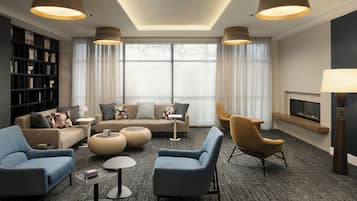 Una sala de estar moderna con un sofá, sillones, una mesa de centro y una chimenea.