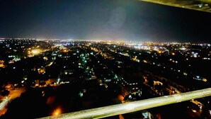 Une vue aérienne nocturne d’une ville, avec ses bâtiments et ses rues illuminés.
