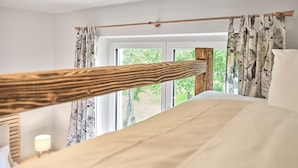 A bedroom with a wooden bunk bed, a bedside lamp, and a window with curtains. - Getaway Apartment 8 Hauser Kaibling (Haus)