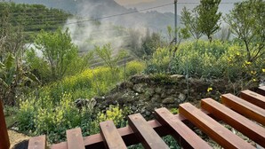 Vista panorámica de un paisaje montañoso con un banco de madera en primer plano.