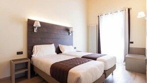 A double bed with a wooden headboard, two bedside tables, and a window with curtains. - Limonaia 1 | Apartment Villa Carobbi (Firenze)