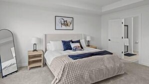 Een slaapkamer met een bed, nachtkastjes, een wanddecoratie en een deur.