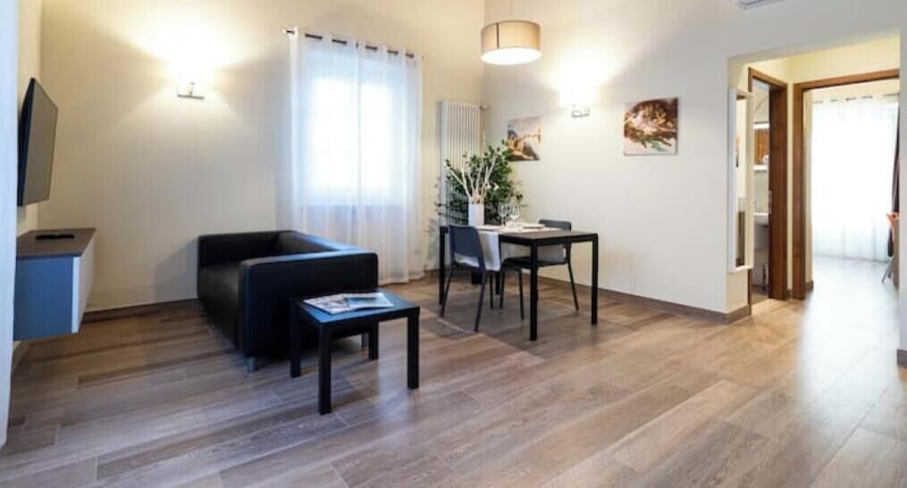Ein modernes Wohnzimmer mit Sofa, Couchtisch und Essbereich.