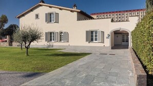 Une maison à deux étages avec un chemin de pierre menant à l’entrée.
