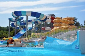 A water park with a large water slide, a pool, and a lifeguard tower. - Beach houses Ive & Beta – romantic oasis, pool, jacuzzi, privacy, near to sea (Pula)