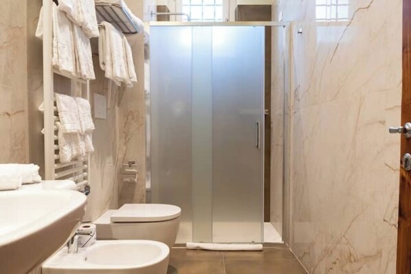 A bathroom with a shower, toilet, and sink.