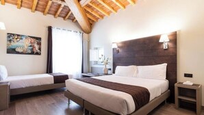 A hotel room with a large bed, a smaller bed, wooden flooring, a painting on the wall, and a window with curtains. - Ancient Well 3 | Villa Carobbi Apt (Firenze)