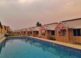 Uma fileira de casas pequenas e padronizadas com uma piscina em primeiro plano.
