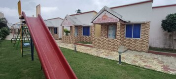 Un parque infantil con un tobogán rojo y una estructura de escalada.