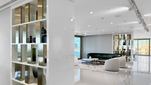 A modern living room with a sofa, coffee table, and decorative shelves.