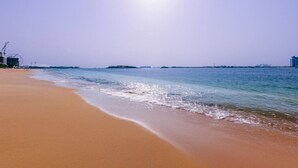 A beach with a clear sky and calm sea.