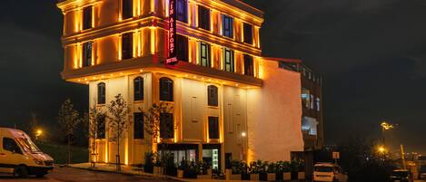 A hotel with a classic architectural style, featuring a prominent sign and a well-lit facade.