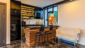 Una cocina moderna con una isla integrada, taburetes de bar y un sofá blanco.