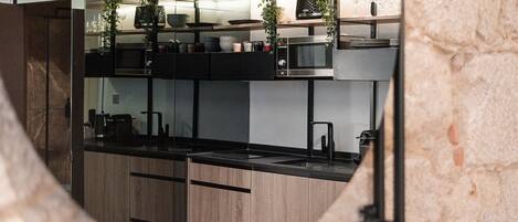 A modern kitchen with wooden cabinets, a black countertop, and a built-in microwave.