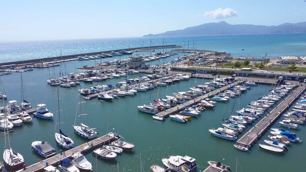 A marina with numerous boats docked at piers, a clear view of the sea, and a distant mountain range. - Casa Puni in seaside (Chiavari)