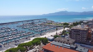 A marina with numerous boats docked, a road leading to the marina, and buildings in the foreground. - Casa Puni in seaside (Chiavari)