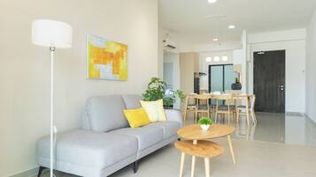 A modern living room with a grey sofa, a round wooden coffee table, and a floor lamp.