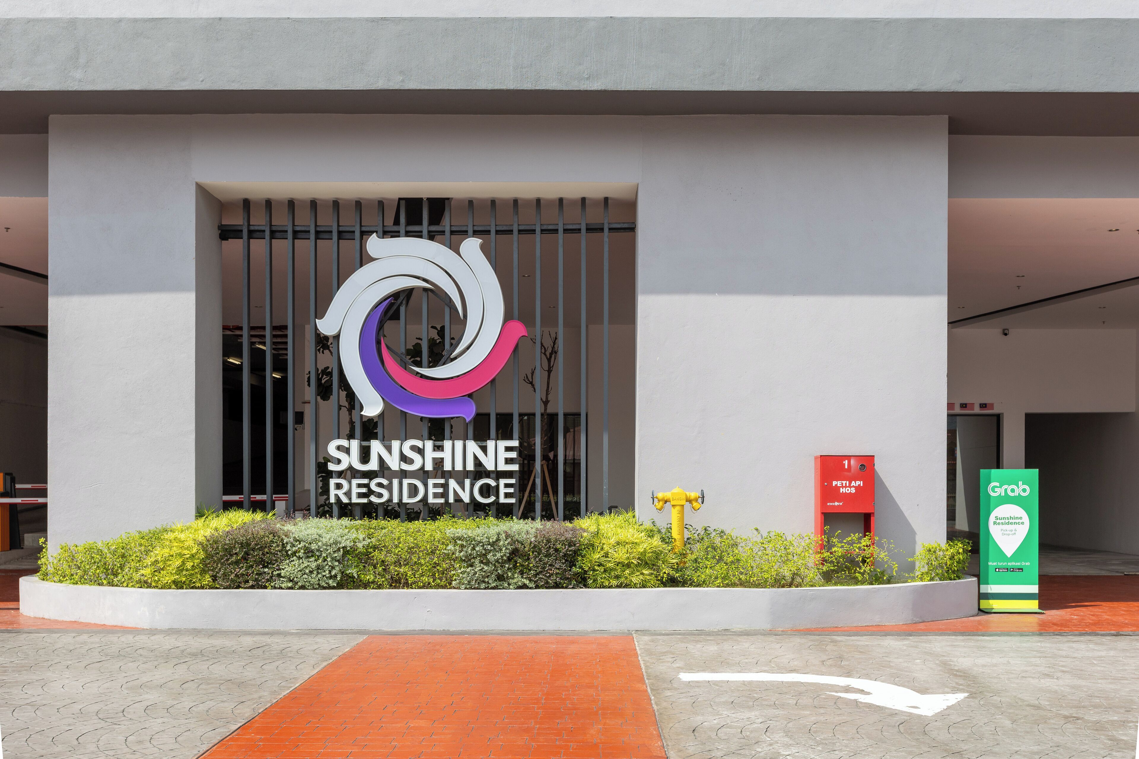A modern building entrance with a sign for Sunshine Residence.