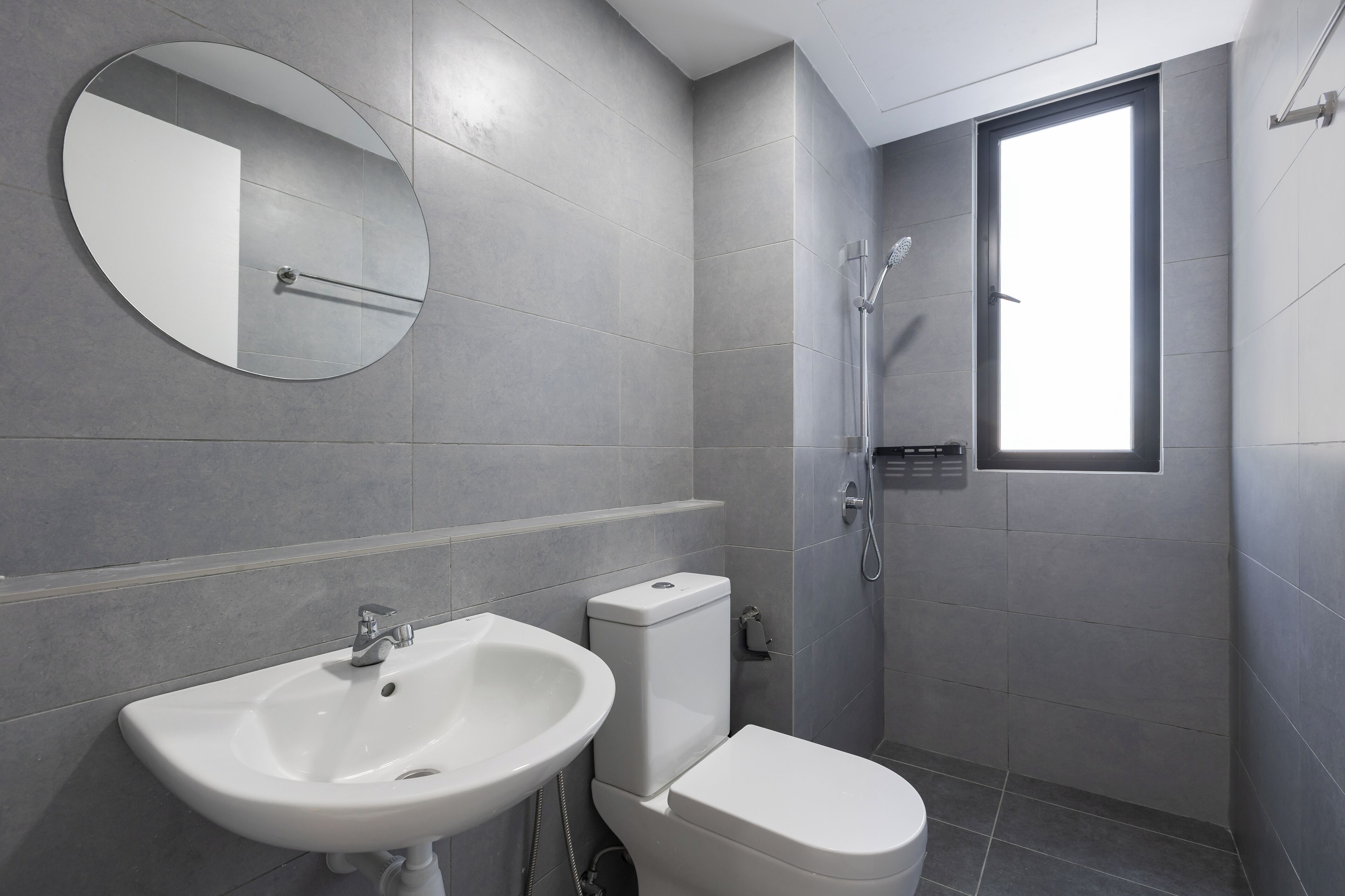 Un baño moderno con lavamanos, inodoro y ducha.
