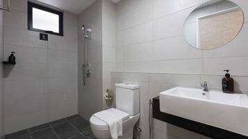 Un baño moderno con inodoro, bidé y lavamanos.